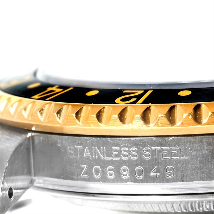 Close-up of the side of a Rolex GMT-Master 16713 Men's Stainless Steel Black Dial 16713 Men's Stainless Steel Black Dial watch, showing the bezel, case, and part of the engraved serial number.