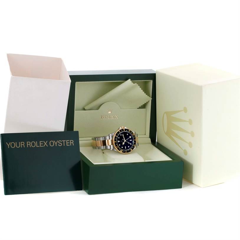 The Rolex GMT-Master 16713 Men's Stainless Steel Black Dial 16713 Men's Stainless Steel Black Dial watch is displayed in a box, with packaging, an instruction manual, and a cleaning cloth visible.