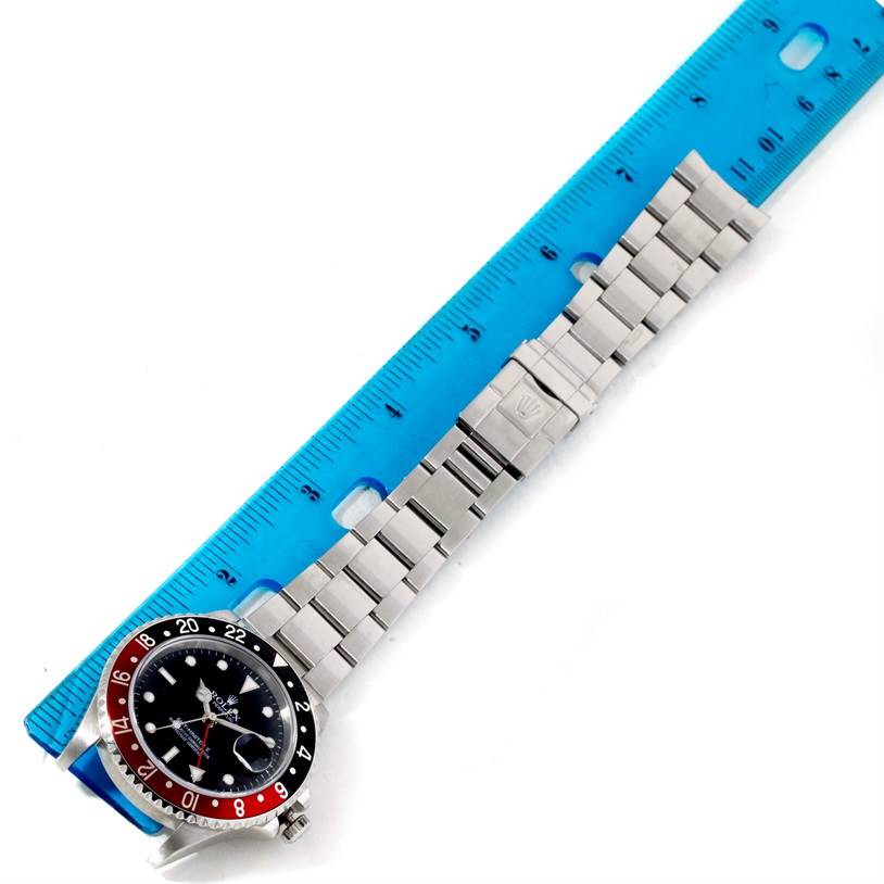 The image shows a Rolex GMT-Master 16710 Men's Stainless Steel Black Dial 16710 Men's Stainless Steel Black Dial watch laid flat next to a blue ruler, displaying both its face and metal bracelet.