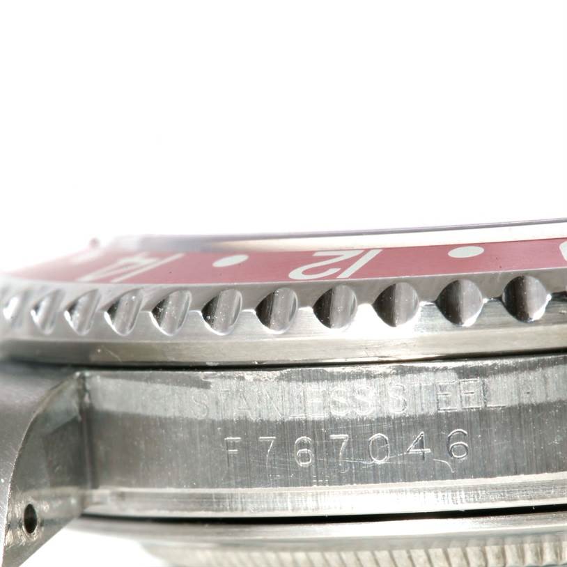 The image shows a close-up of the side of a Rolex GMT-Master 16710 Men's Stainless Steel Black Dial 16710 Men's Stainless Steel Black Dial watch, focusing on the bezel and case with visible serial numbers.