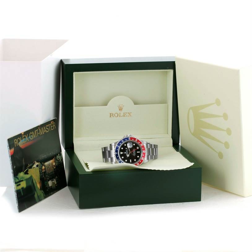 The Rolex GMT-Master 16710 Men's Stainless Steel Black Dial 16710 Men's Stainless Steel Black Dial is shown front-facing in its open display box with a booklet on the side.