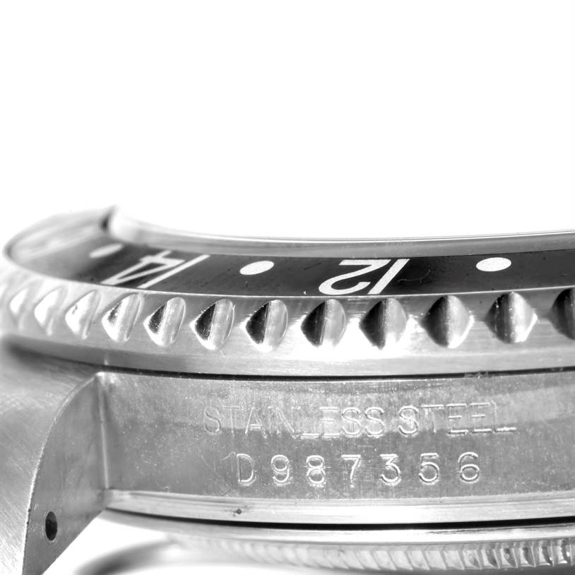 The image shows a close-up side view of a Rolex GMT-Master 16710 Men's Stainless Steel Black Dial 16710 Men's Stainless Steel Black Dial watch, highlighting its bezel, part of the dial, and case with engraved serial numbers.