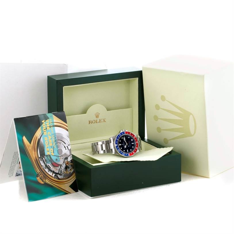 The Rolex GMT-Master 16710 Men's Stainless Steel Black Dial 16710 Men's Stainless Steel Black Dial watch is displayed at a slight angle inside its open box, with the booklet and outer box also visible.