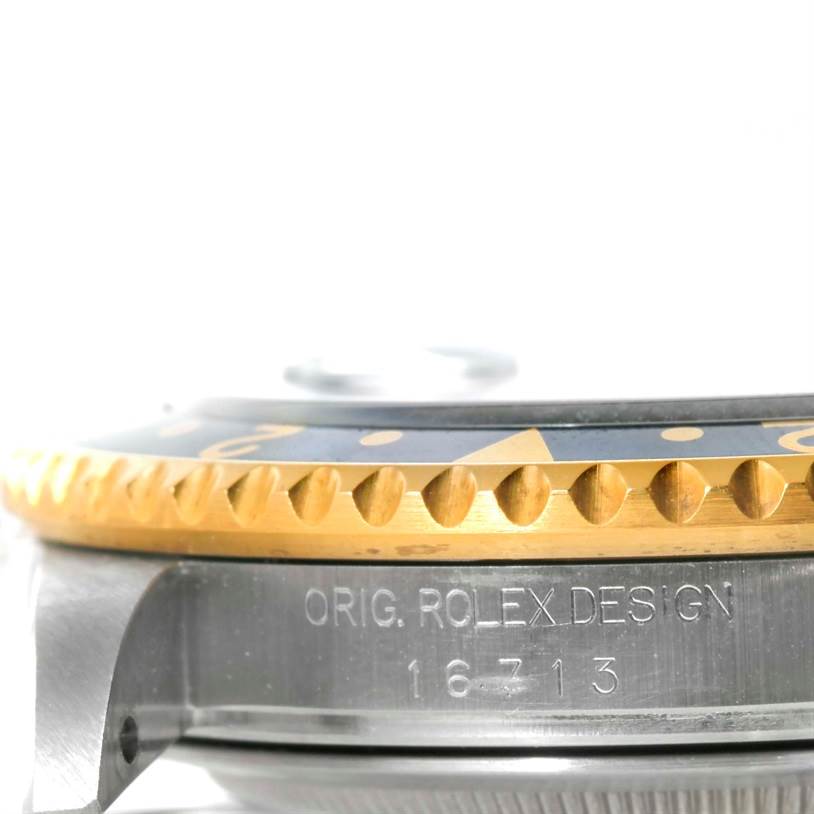 The side view of the Rolex GMT-Master 16713 Men's Stainless Steel Black Dial 16713 Men's Stainless Steel Black Dial shows the bezel and part of the case with engraved "ORIG. ROLEX DESIGN 16713."