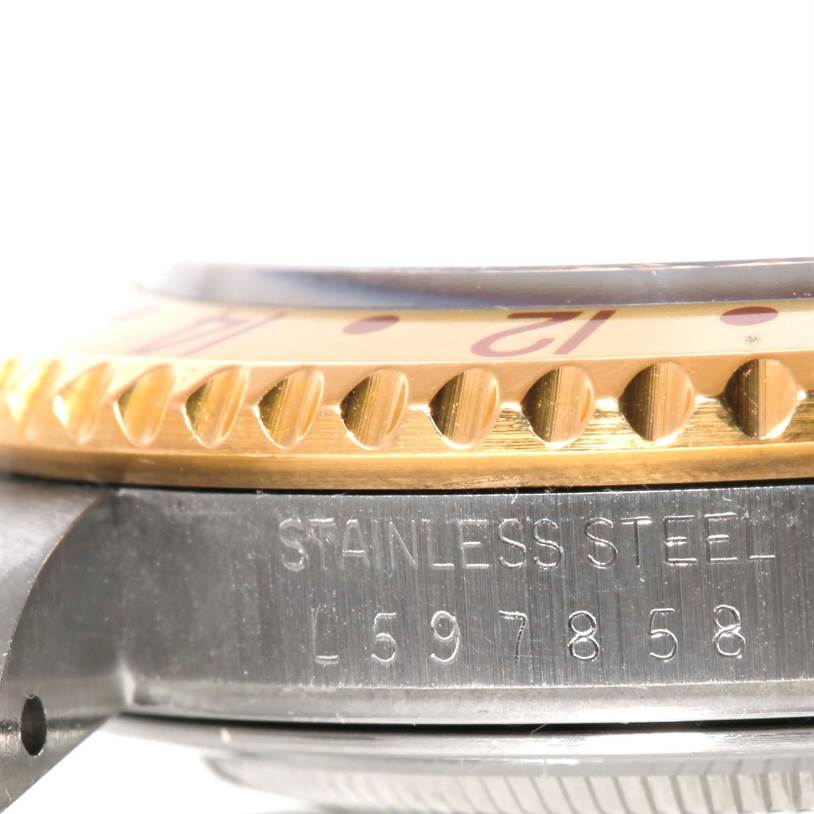 This close-up image of a Rolex GMT-Master 16713 Men's Stainless Steel Brown Dial 16713 Men's Stainless Steel Brown Dial watch shows the side profile of the bezel and the stainless steel case with the serial number.