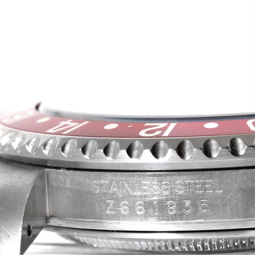 The image shows a close-up side view of the bezel and case of a Rolex GMT-Master 16710 Men
s Stainless Steel Black Dial 16710 Men
s Stainless Steel Black Dial watch, including part of the engraved serial number.