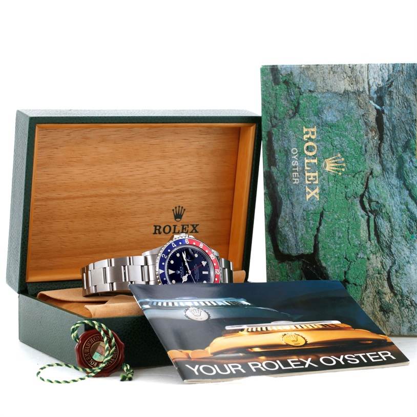 The image shows a Rolex GMT-Master 16700 Men's Stainless Steel Black Dial 16700 Men's Stainless Steel Black Dial watch in its open box, accompanied by the box cover and a booklet.