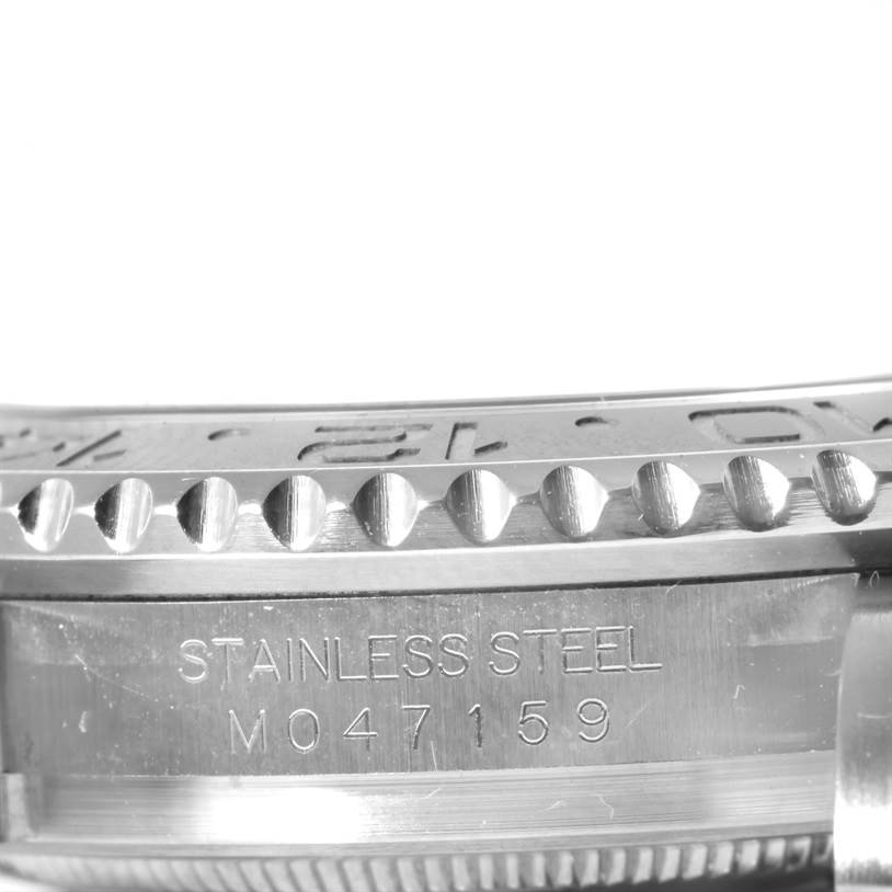 This image shows a close-up of the bezel and part of the case of a Rolex GMT-Master 116710 Men's Stainless Steel Black Dial 116710 Men's Stainless Steel Black Dial watch, highlighting the stainless steel material and serial number.