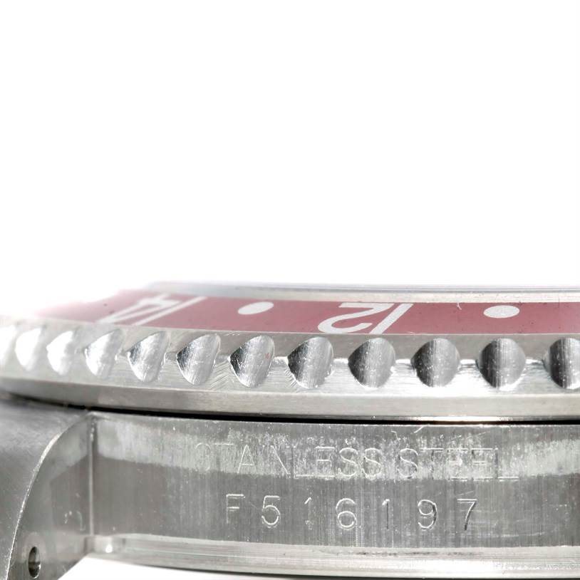 The image shows a close-up side view of a Rolex GMT-Master 16710 Men's Stainless Steel Black Dial 16710 Men's Stainless Steel Black Dial watch, focusing on the bezel and part of the watch case with its serial number.