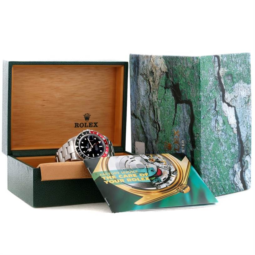 The Rolex GMT-Master 16710 Men's Stainless Steel Black Dial 16710 Men's Stainless Steel Black Dial watch is shown at a slight angle inside an open box, with accompanying booklets and outer packaging visible.