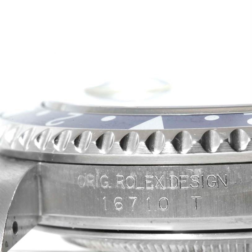 This image shows a close-up of the side view of a Rolex GMT-Master 16710 Men's Stainless Steel Black Dial 16710 Men's Stainless Steel Black Dial bezel and case, displaying the "ORIG. ROLEX DESIGN 16710 T" engraving.