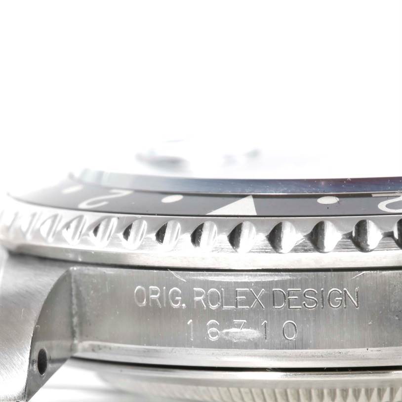 This close-up image of the Rolex GMT-Master 16710 Men's Stainless Steel Black Dial 16710 Men's Stainless Steel Black Dial watch showcases the side view, focusing on the bezel and model number engraving.