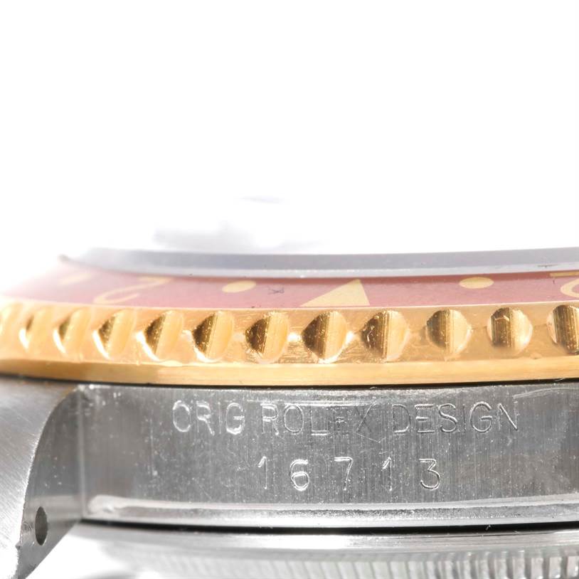 This close-up shot of a Rolex GMT-Master 16713 Men's Stainless Steel Brown Dial 16713 Men's Stainless Steel Brown Dial shows the watch's bezel, case, and engraved model number (16713).
