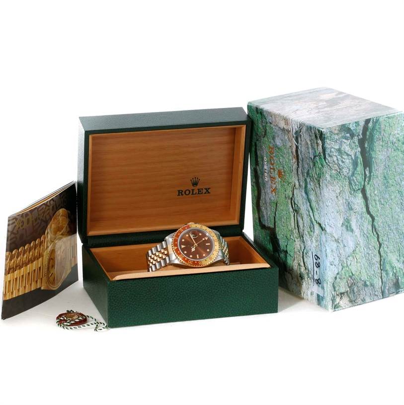 The Rolex GMT-Master 16713 Men's Stainless Steel Brown Dial 16713 Men's Stainless Steel Brown Dial watch is shown inside its open box, with the outer box and booklet displayed beside it.