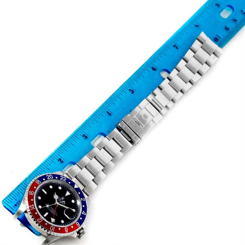 The image shows a top-down view of a Rolex GMT-Master 16710 Men's Stainless Steel Black Dial 16710 Men's Stainless Steel Black Dial watch, highlighting the bezel, dial, and bracelet with a ruler for scale.