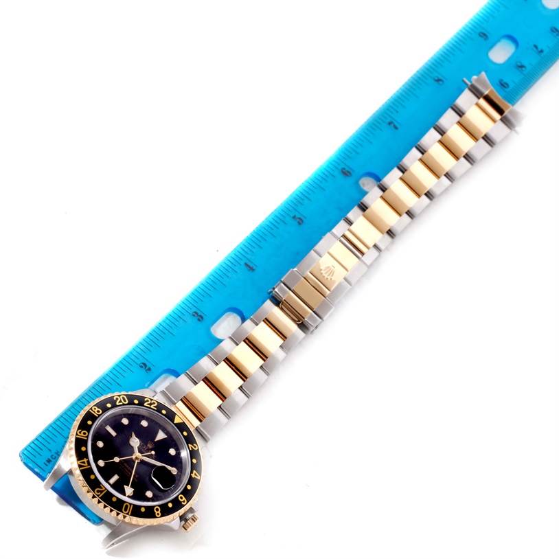 The image shows a top-down view of a Rolex GMT-Master 16713 Men's Stainless Steel Black Dial 16713 Men's Stainless Steel Black Dial watch, highlighting its bezel, face, and entire bracelet against a ruler.