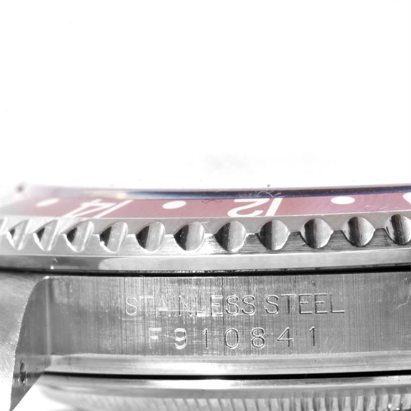 This close-up image of the Rolex GMT-Master 16710 Men's Stainless Steel Black Dial 16710 Men's Stainless Steel Black Dial watch shows the side view, focusing on the bezel and engraved serial number.