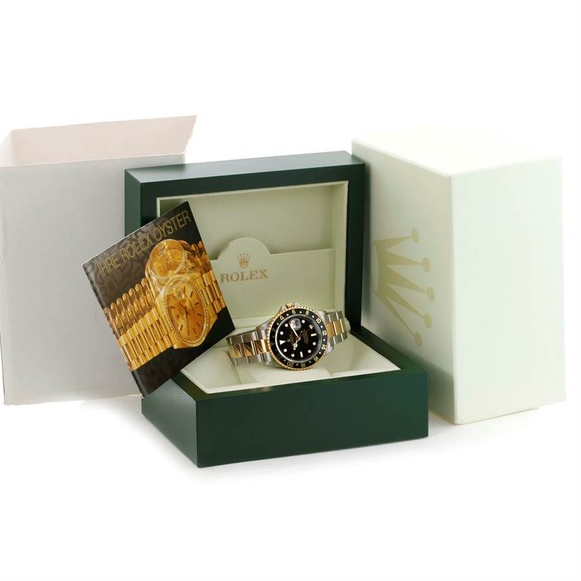 The Rolex GMT-Master 16713 Men's Stainless Steel Black Dial 16713 Men's Stainless Steel Black Dial watch is displayed at a front angle in its green box with a booklet and outer white box visible.