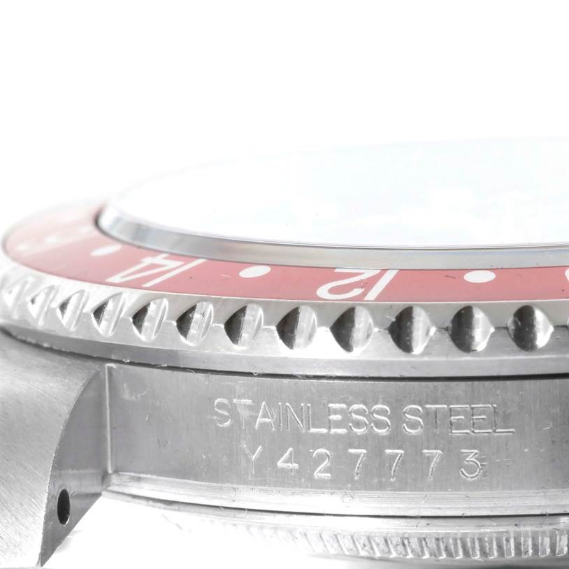 The image shows a close-up side view of the bezel and case of a Rolex GMT-Master 16710 Men
s Stainless Steel Black Dial 16710 Men
s Stainless Steel Black Dial watch, highlighting the serial number engraving.