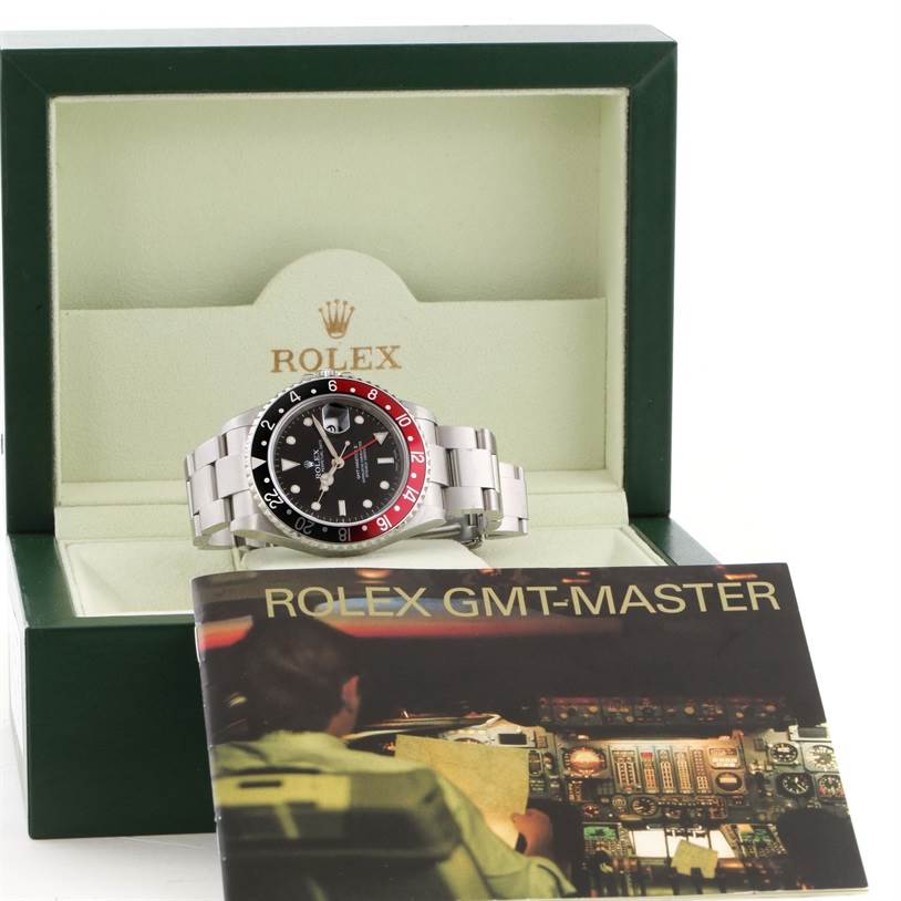 The Rolex GMT-Master 16710 Men's Stainless Steel Black Dial 16710 Men's Stainless Steel Black Dial watch is shown at a frontal angle inside its open green box with a booklet in front.