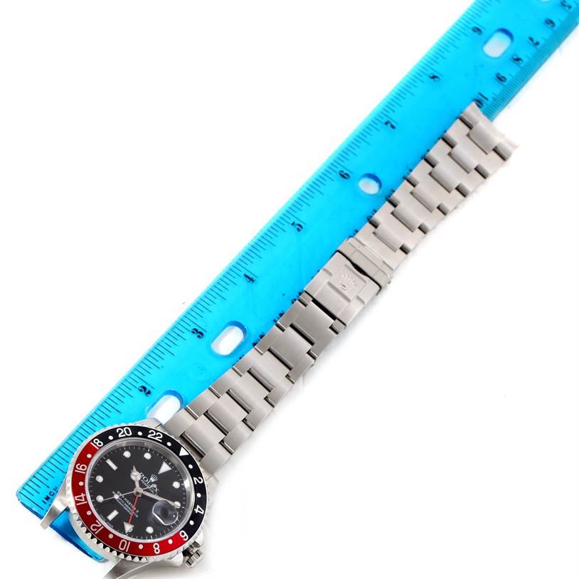 The image shows a Rolex GMT-Master 16710 Men's Stainless Steel Black Dial 16710 Men's Stainless Steel Black Dial watch laid flat, with its face, bezel, and bracelet visible alongside a blue measuring ruler.