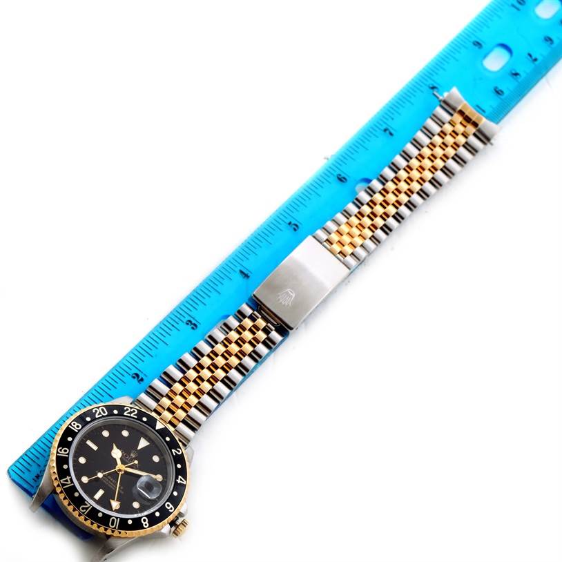 The image shows a Rolex GMT-Master 16713 Men
s Stainless Steel Black Dial 16713 Men
s Stainless Steel Black Dial watch laid flat alongside a ruler, with the dial, bezel, and Jubilee bracelet visible.