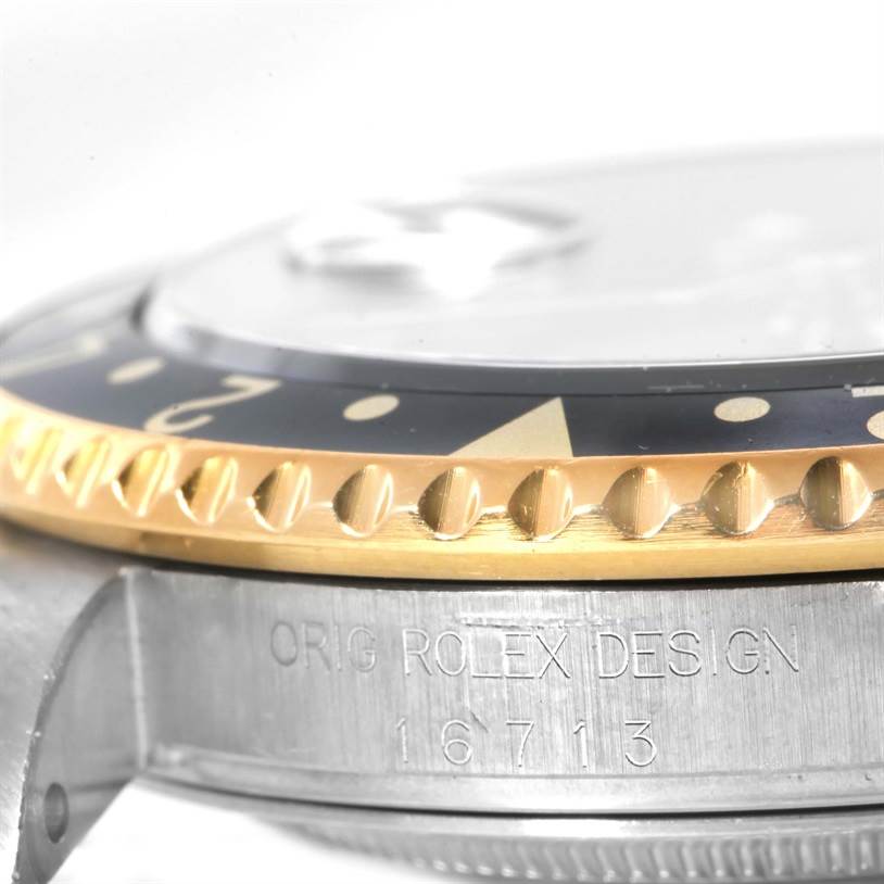 The image shows a side angle of the bezel and case of a Rolex GMT-Master 16713 Men
s Stainless Steel Black Dial 16713 Men
s Stainless Steel Black Dial model, highlighting the engraving "ORIG ROLEX DESIGN."