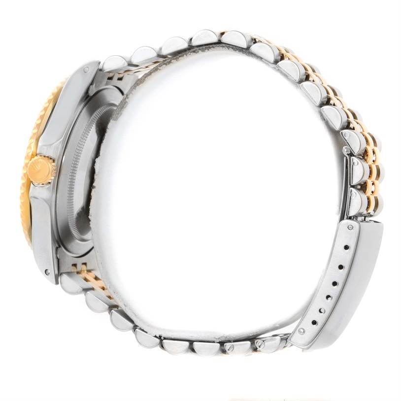 The image shows a side view of a Rolex GMT-Master 16713 Men
s Stainless Steel Black Dial 16713 Men
s Stainless Steel Black Dial watch, highlighting its gold crown and two-tone metal bracelet.