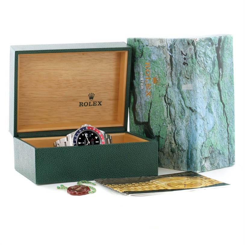 The image shows a Rolex GMT-Master 16710 Men's Stainless Steel Black Dial 16710 Men's Stainless Steel Black Dial watch in its open green box, with its outer box and accessories nearby.