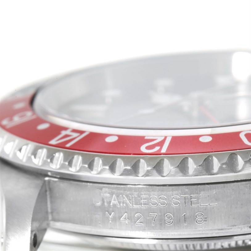 This close-up image of the Rolex GMT-Master 16710 Men's Stainless Steel Black Dial 16710 Men's Stainless Steel Black Dial watch shows the bezel, case, and part of the engraved serial number.