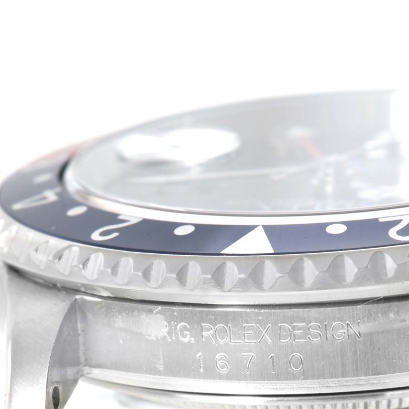 This image displays a side angle of a Rolex GMT-Master 16710 Men's Stainless Steel Black Dial 16710 Men's Stainless Steel Black Dial watch, focusing on the bezel and part of the engraving on the case.