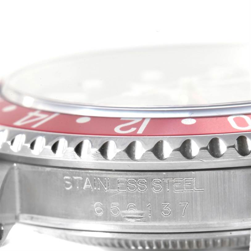 This close-up image of a Rolex GMT-Master 16710 Men's Stainless Steel Black Dial 16710 Men's Stainless Steel Black Dial watch shows the side of the bezel and the stainless steel case with model engravings.