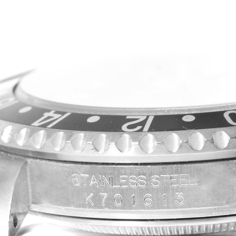 This image shows a close-up side view of a Rolex GMT-Master 16710 Men's Stainless Steel Black Dial 16710 Men's Stainless Steel Black Dial bezel, focusing on the bezel numbers, edge markers, and serial engraving.