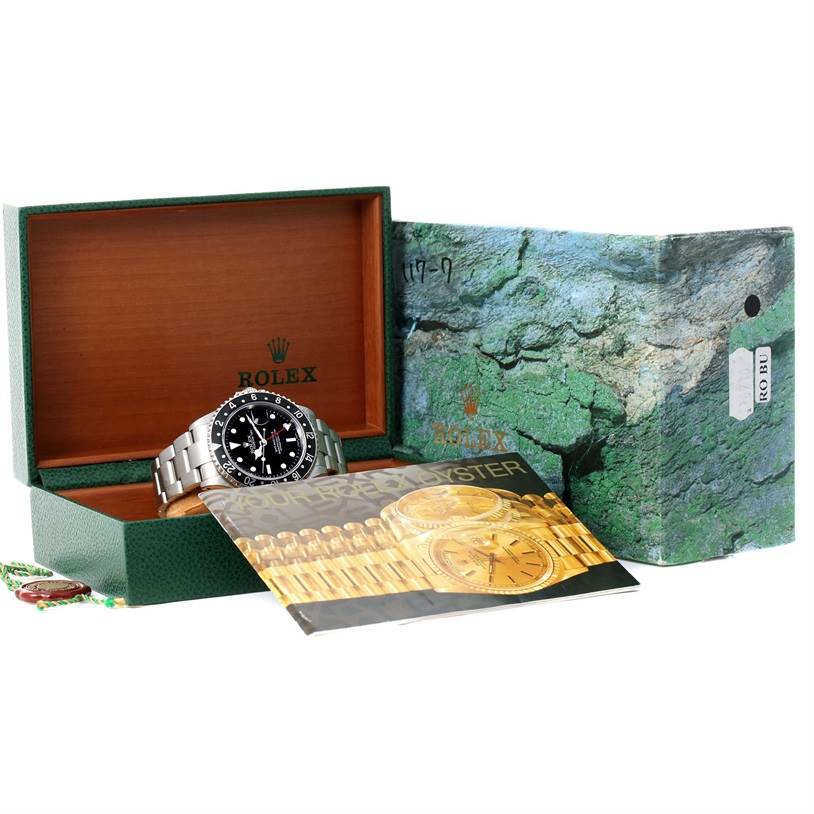 This image shows a Rolex GMT-Master 16710 Men's Stainless Steel Black Dial 16710 Men's Stainless Steel Black Dial watch partially inside its open wooden box with manuals and packaging visible.