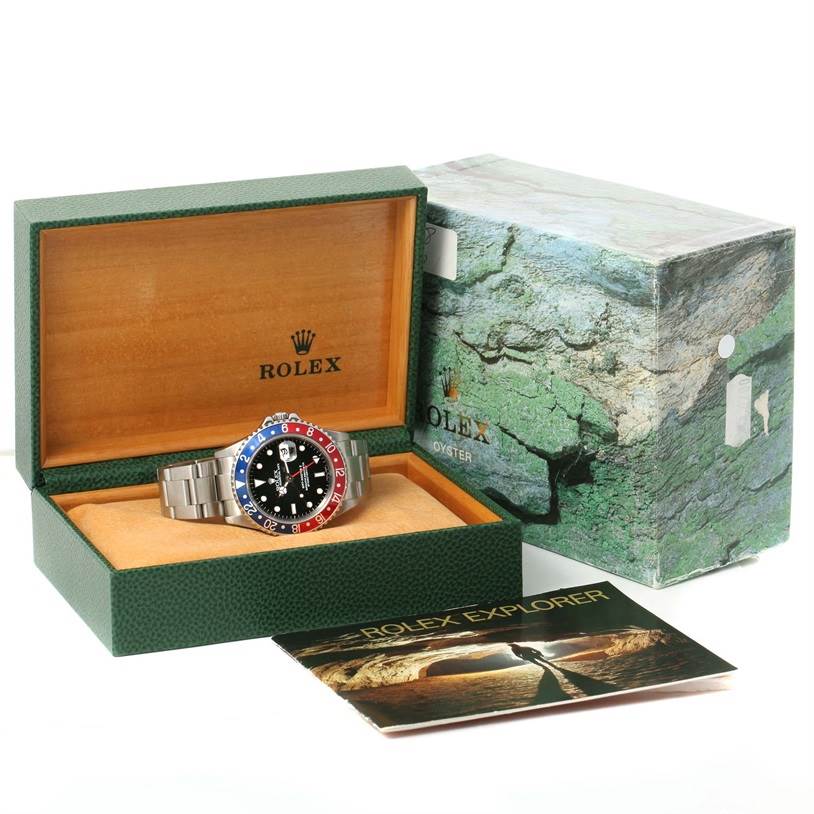 The Rolex GMT-Master 16710 Men's Stainless Steel Black Dial 16710 Men's Stainless Steel Black Dial watch is shown in an open box with the watch facing forward, alongside its outer box and a booklet.