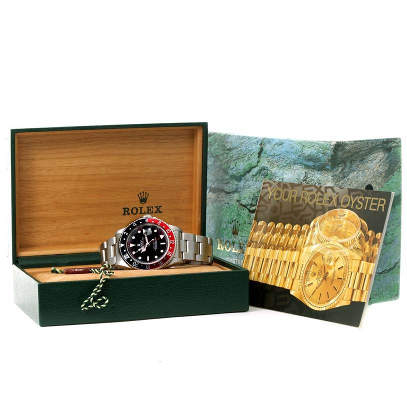 The Rolex GMT-Master 16700 Men's Stainless Steel Black Dial 16700 Men's Stainless Steel Black Dial watch is displayed in its open box with the instruction manual and protective packaging visible.