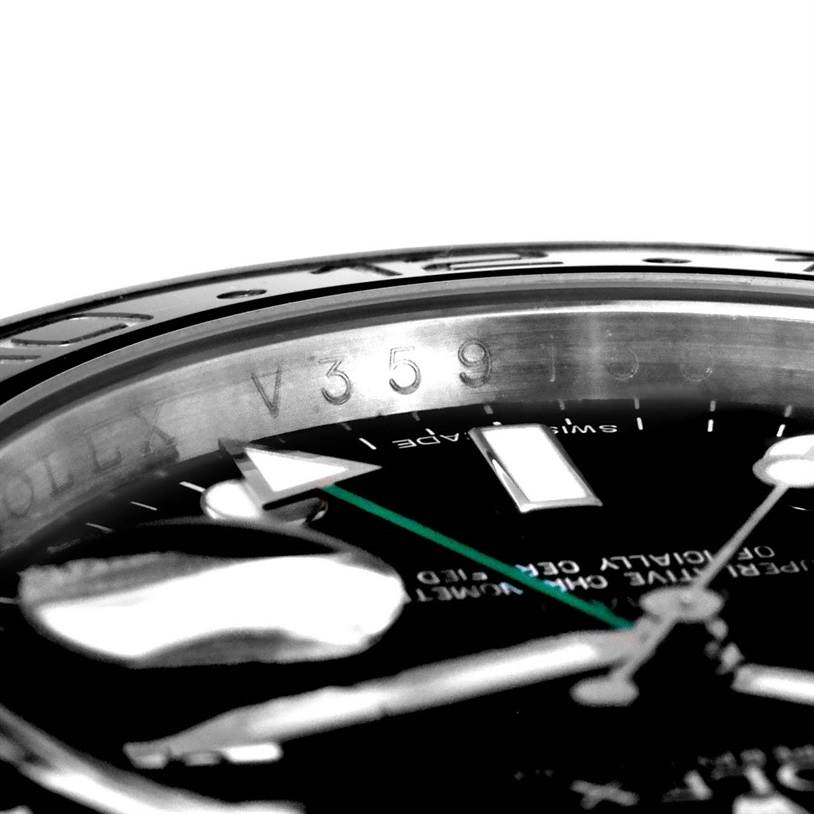 This close-up image of a Rolex GMT-Master 116710 Men
s Stainless Steel Black Dial 116710 Men
s Stainless Steel Black Dial watch shows the bezel, part of the dial, and the engraved serial number on the inner ring.