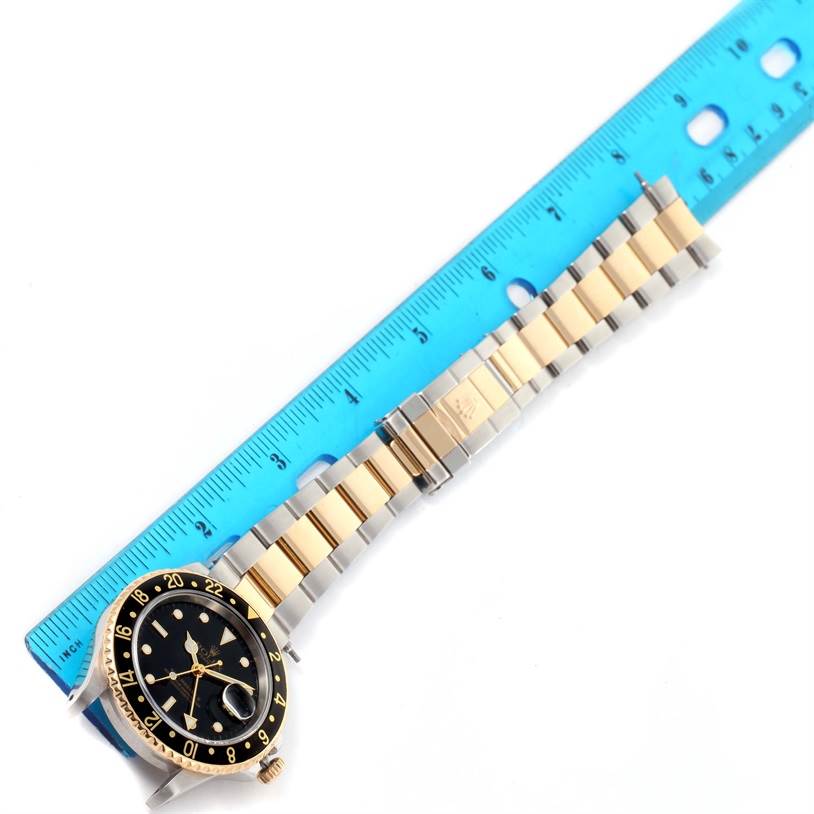 The image shows a Rolex GMT-Master 16713 Men's Stainless Steel Black Dial 16713 Men's Stainless Steel Black Dial watch laid flat next to a blue ruler, showcasing the face, bezel, bracelet, and clasp.