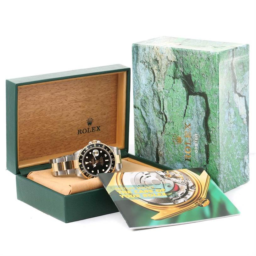 The image shows a Rolex GMT-Master 16713 Men's Stainless Steel Black Dial 16713 Men's Stainless Steel Black Dial watch displayed in an open green and wooden box with a booklet and an outer box.