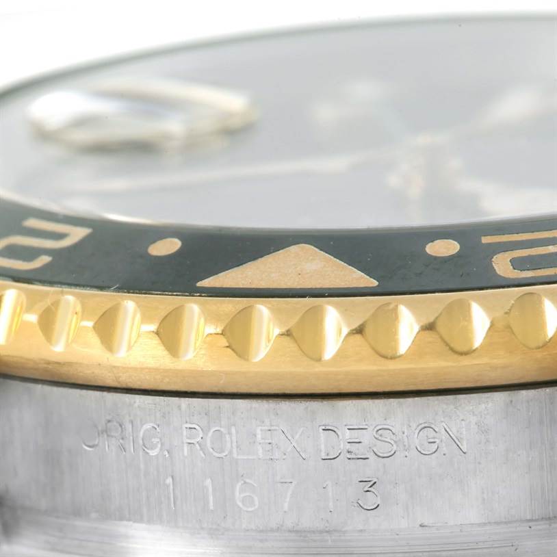 The close-up image of the Rolex GMT-Master 116713 Men
s Stainless Steel Black Dial 116713 Men
s Stainless Steel Black Dial shows the bezel, part of the dial, and engraved case details.