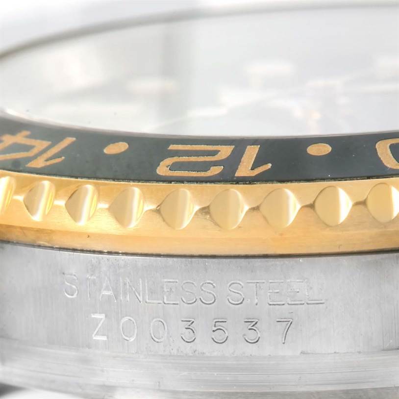 This close-up image shows the bezel detailing and the engraved serial number on the casing of a Rolex GMT-Master 116713 Men
s Stainless Steel Black Dial 116713 Men
s Stainless Steel Black Dial watch.