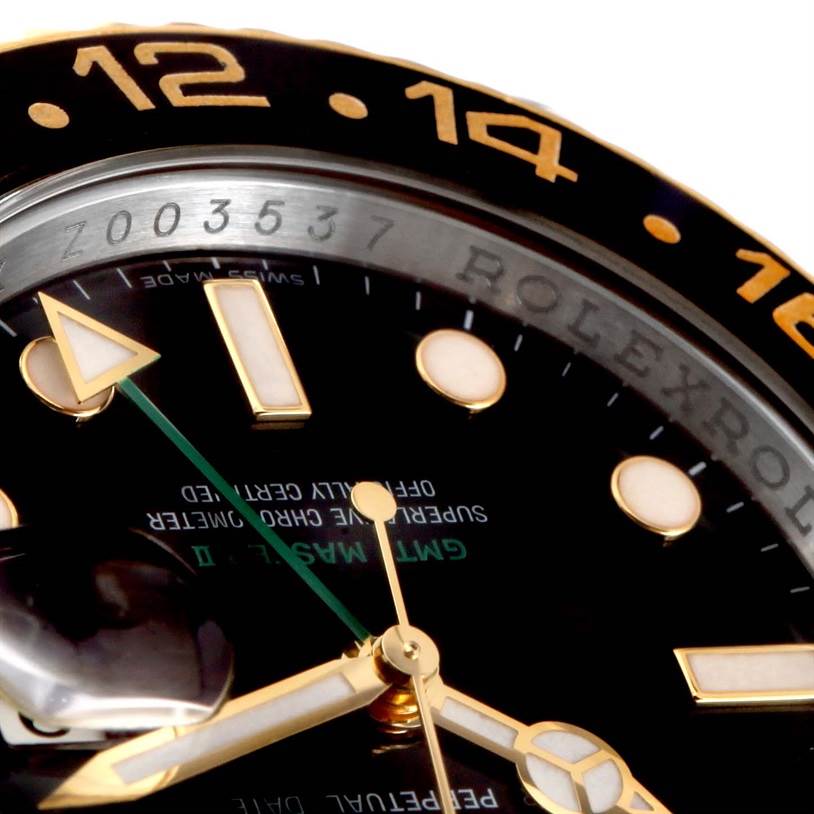 This close-up image of a Rolex GMT-Master 116713 Men
s Stainless Steel Black Dial 116713 Men
s Stainless Steel Black Dial watch shows the bezel, part of the dial, hands, and hour markers.