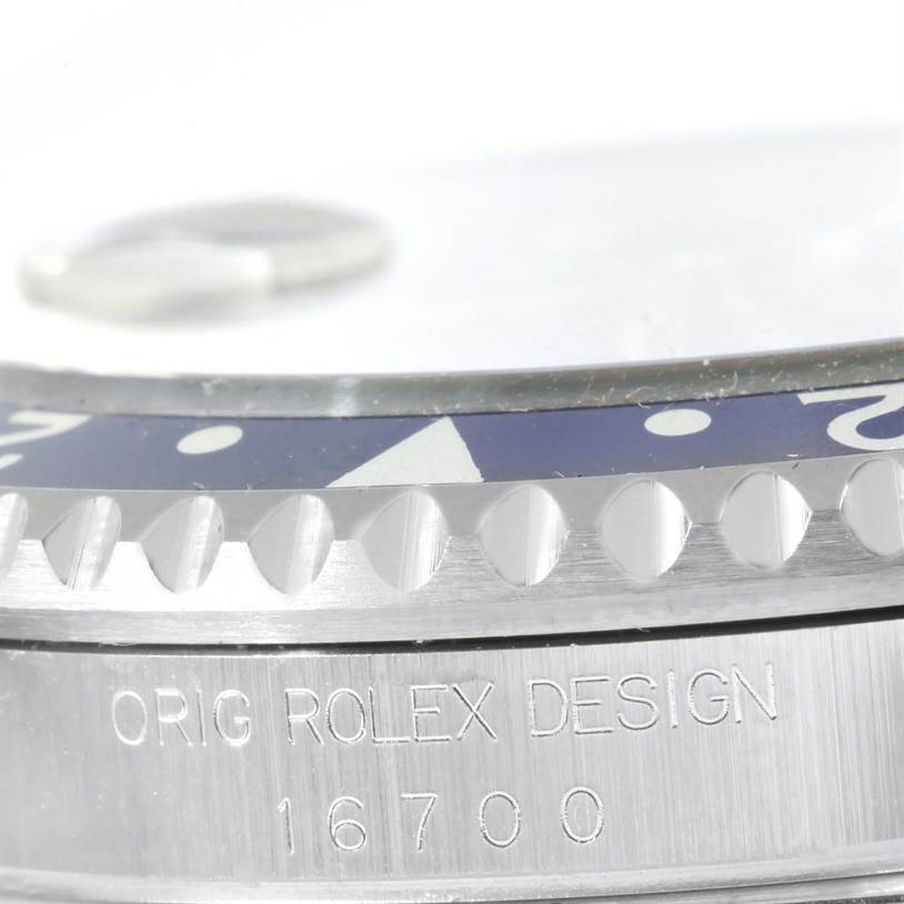 The image shows an angled close-up of a Rolex GMT-Master 16700 Men's Stainless Steel Black Dial 16700 Men's Stainless Steel Black Dial model 16700, highlighting the bezel and "ORIG ROLEX DESIGN" engraving.