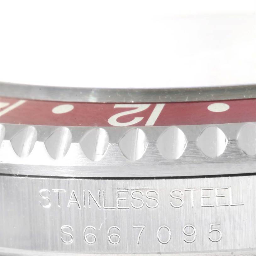 The image shows a close-up angle of the bezel and case of the Rolex GMT-Master 16700 Men's Stainless Steel Black Dial 16700 Men's Stainless Steel Black Dial, with "Stainless Steel" engraved on the case.