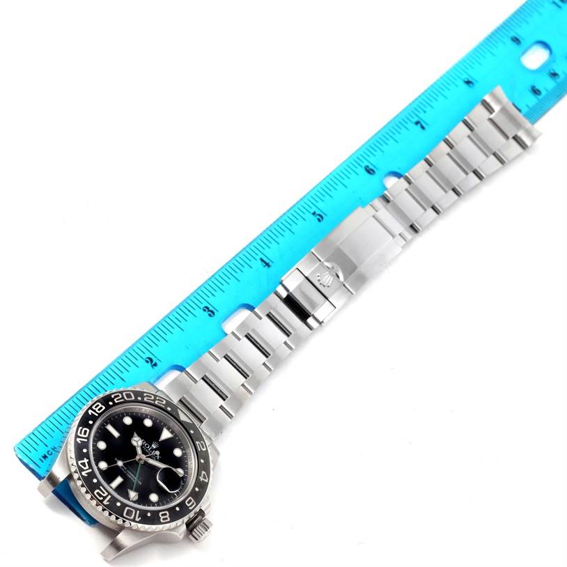 The image shows the full face, bezel, and bracelet of a Rolex GMT-Master 116710 Men's Stainless Steel Black Dial 116710 Men's Stainless Steel Black Dial watch, positioned alongside a blue ruler.