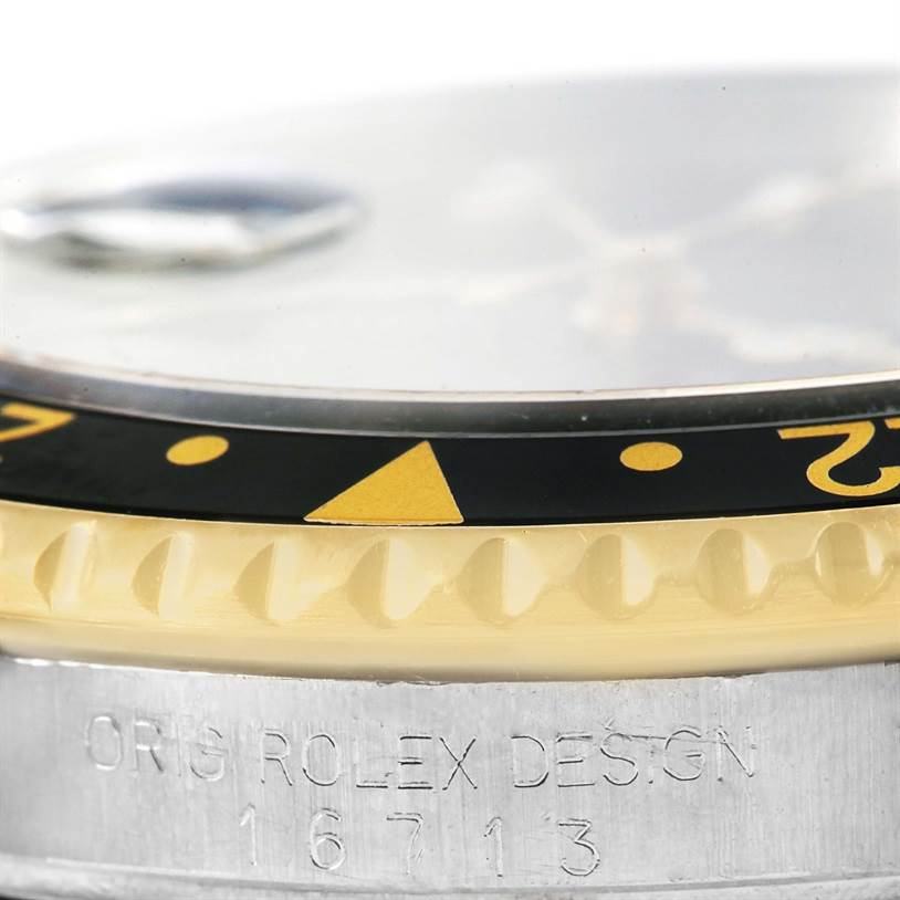 This image shows a close-up view of the bezel and engraved case of a Rolex GMT-Master 16713 Men's Stainless Steel Black Dial 16713 Men's Stainless Steel Black Dial watch.