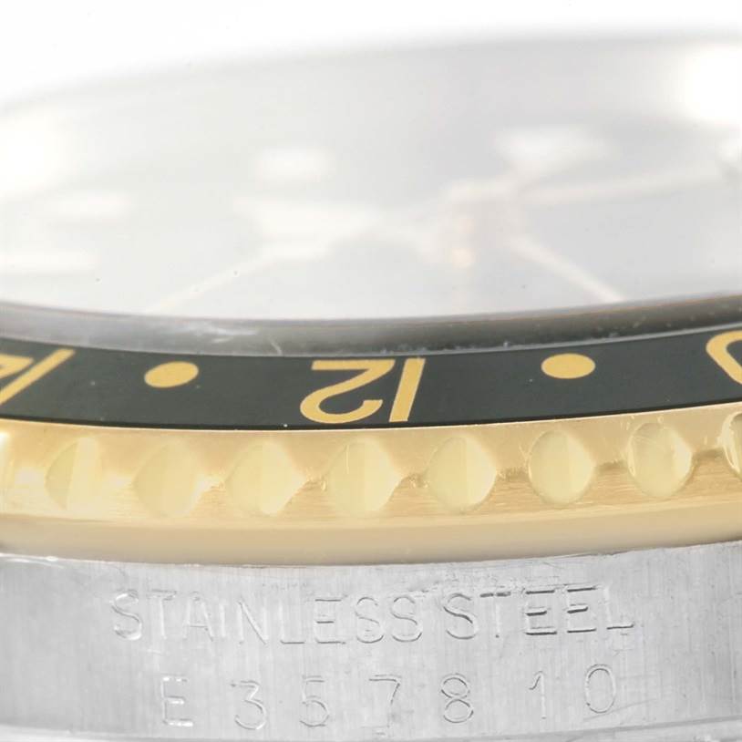 This close-up image of a Rolex GMT-Master 16713 Men's Stainless Steel Black Dial 16713 Men's Stainless Steel Black Dial watch shows the side view of the bezel and part of the case with "STAINLESS STEEL" engraved.