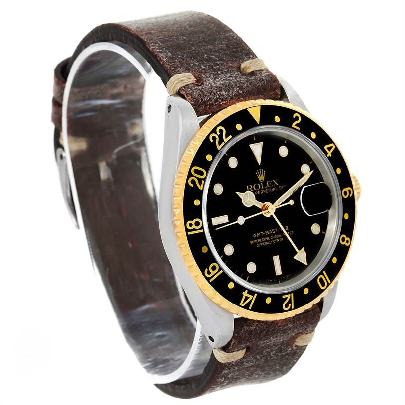 The image shows a Rolex GMT-Master 16713 Men's Stainless Steel Black Dial 16713 Men's Stainless Steel Black Dial watch at a three-quarter angle, highlighting its black dial, gold bezel, and leather strap.