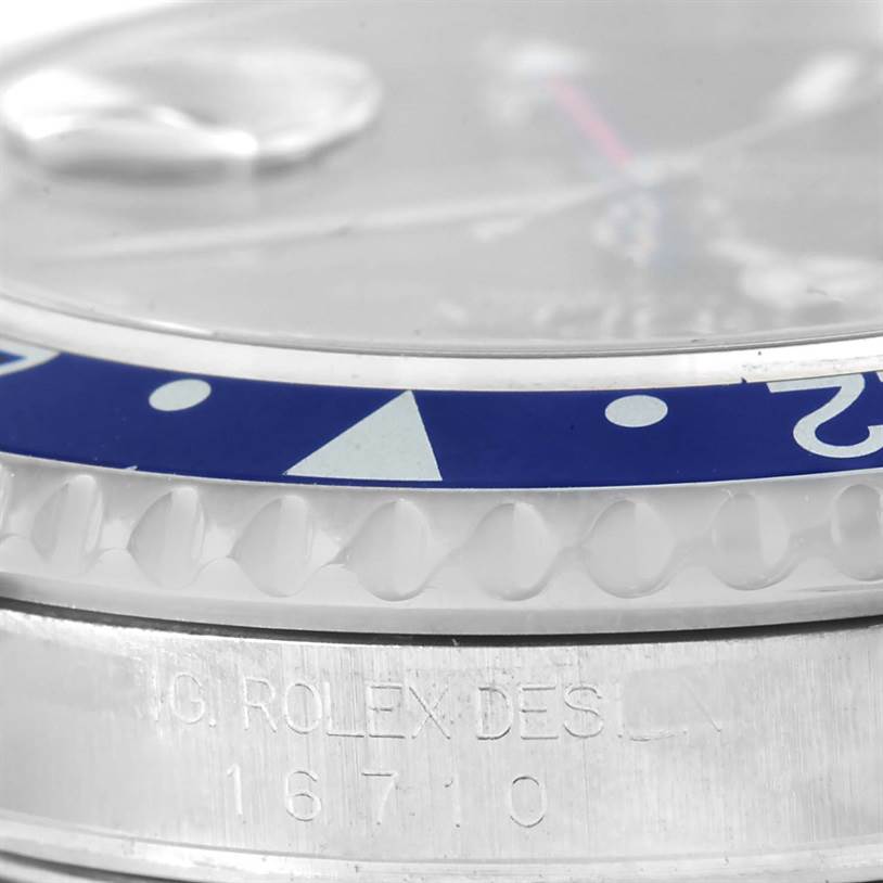 The image shows a close-up angle of the bezel, crystal, and engraved serial number of a Rolex GMT-Master 16710 Men's Stainless Steel Black Dial 16710 Men's Stainless Steel Black Dial model.