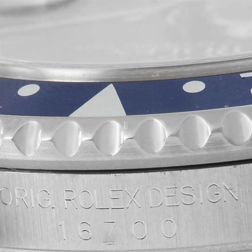 This close-up angle of the Rolex GMT-Master 16700 Men's Stainless Steel Black Dial 16700 Men's Stainless Steel Black Dial watch shows the bezel and part of the case with the model number 16700 engraved.